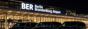 Premium Mercedes V-Class MPVs waiting for passengers at the Berlin Brandenburg Airport (BER) terminal at night
